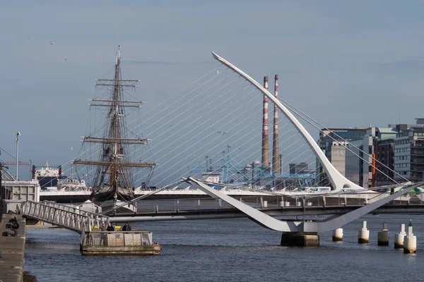 Dublin, İrlanda 'daki Liffey Nehri' nin aşağısına Samuel Beckett Köprüsü, havuzcu bacaları ve kıtlık gemisi ile sıkıştırılmış bakış açısı. 