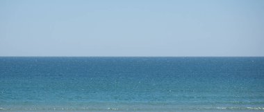 Deniz ve gökyüzü, ufuk çizgisi tam ortada, görüntüyü yatay olarak ikiye bölüyor. Web pankartı veya arkaplan.