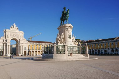 Lizbon 'da güneşli bir günde mavi gökyüzü ile Comercio antrenmanı. Kral Jose 'nin heykeli ve Rua Augusta' nın zafer kemeri..