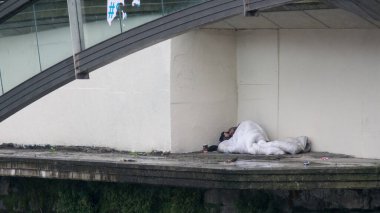 Yağmurda köprü altında uyuyan evsiz biri. Dublin, İrlanda.