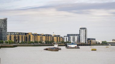 Londra 'daki Thames nehrinin üzerinden Deptford' a doğru nehir ve karşı kıyıdaki Glaisher Caddesi 'ndeki apartman binalarına bakın..