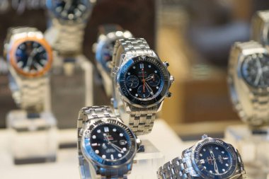 Lüks Omega Seamaster saatleri bir mağaza vitrininde sergileniyor, yüzeysel alan derinliği.