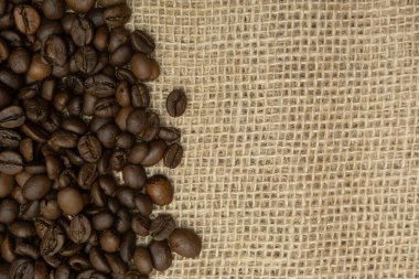 Taze kavrulmuş kahve çekirdekleri çuval bezinin üzerinde duruyor.