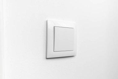 Beyaz boyalı bir duvarda modern beyaz elektrik düğmesi