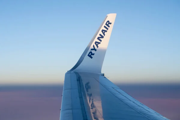 RyanAir logosu uçak penceresinden bulutların üzerinde uçan uçağın kanat ucunda
