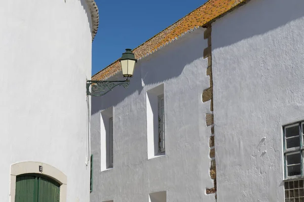 Traditional white buildings in Faro, Algarve, Portugal with old street lamp