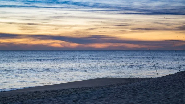 夕阳西下时海滩上的钓竿在轮廓上 葡萄牙阿尔加夫Faro — 图库照片