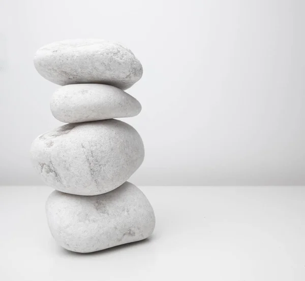 Tall Stack White Stones Pebbles White Table White Wall Background — Stock Photo, Image