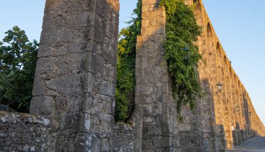 Vila do Conde, Portekiz 'de Santa Clara Aqueduct' un tarihi eserleri. Gün batımında, sarmaşıklar büyüyen taş işçiliğiyle
