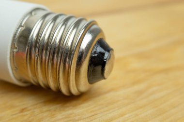 E27 ampulü vida montajına yakın. Ahşap arkaplan.