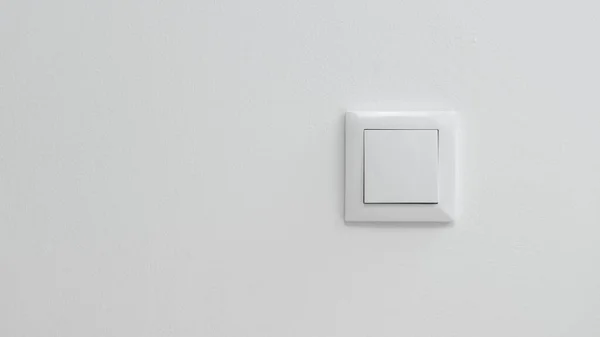 Solunda kopyalama alanı olan beyaz bir duvarda beyaz elektrik düğmesi.