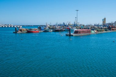 Portekiz 'de balıkçı tekneleri ve ağları kuruyan geniş açılı balıkçı limanı. Mavi gökyüzü ile güneşli bir gün.