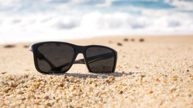 Kumsalda duran güneş gözlükleri. Yüzeyin derinliği.