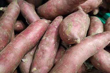 Kırmızı tatlı patates yığını. Kapat.