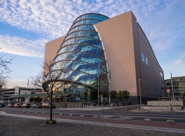 İrlanda 'daki Dublin Kongre Merkezi. Mavi gökyüzü ve beyaz bulutun cama yansıdığı güneşli bir gün..