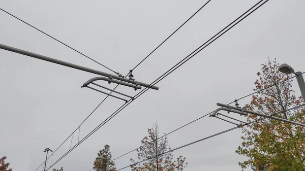 ライトレールラインの上に停止した電気鉄道 トラムケーブル 白い曇りの空 — ストック写真