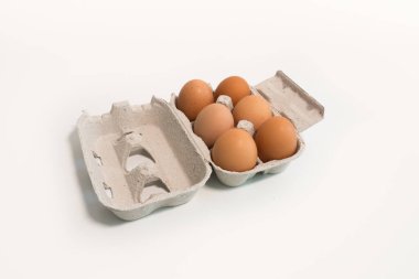 Beyaz bir masada altı yumurtalı yumurta kutusu.