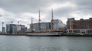 İtalyan Donanma eğitim gemisi Amerigo Vespucci, İrlanda 'nın Dublin kentinde Liffey Nehri' ne yanaştı. 18. yüzyıl tarzında uzun bir gemi. Hat gemisi. Geniş açı, modern cam ve çelik binalar arka planda..