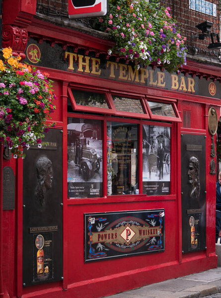 Colorful Irish Pub exterior in Temple Bar Dublin, Ireland with flowers outside.