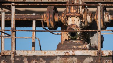 Terk edilmiş rıhtımda eski, paslı, harap metal bir vinç var. Kapat..