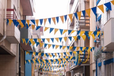 Portekiz 'in Povoa de Varzim kentinde düzenlenen Sao Pedro festivalini kutlamak için pankart ve flamalarla süslenmiş sokak.