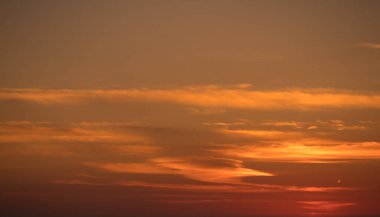 Gün batımında ince ince ince bulutlarla renkli turuncu eğimli gökyüzü