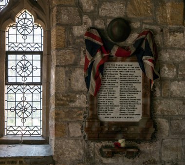 Birinci Dünya Savaşı 'nda kaybolan askerlerin anısına İngiliz Ordusu miğferi ve kilisede haşhaş taşıyan İngiliz bayrağı. Ponteland, Northumberland, İngiltere 'deki tarihi St. Mary kilisesinde..