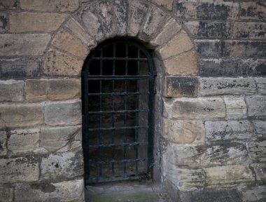 Eski taş kalede parmaklıkları olan zindan hücresi.