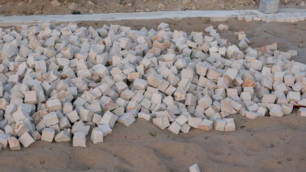 Stones in sand for construction of a Portuguese sidewalk / pavement in Portugal.