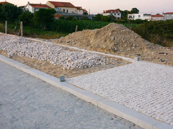Portuguese sidewalk / pavement under construction in Vila do Conde, Portugal with sand and cobblestones.
