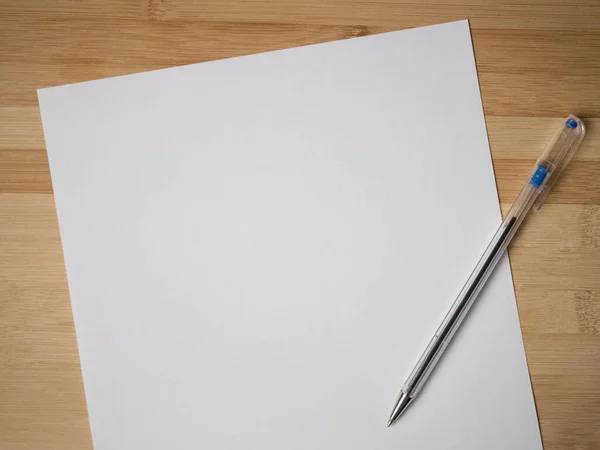 単板の白い紙と天然木の机の背景の角度でボールペン — ストック写真