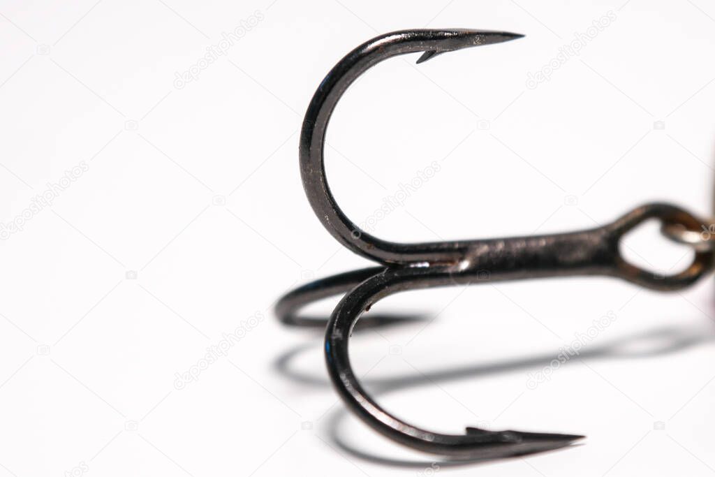 Point and barb of a treble fishing hook. Close up / macro image with copy space on left