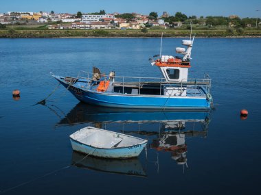 Nehirde küçük bir balıkçı teknesi Vila do Conde, Porto, Portekiz 'de güneşli bir günde ön planda beyaz botla