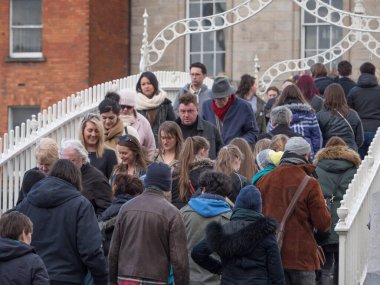 İrlanda, Dublin 'deki yarım peni köprüsünden bir sürü insan geçiyor. Sıkıştırılmış bakış açısı