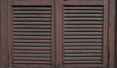 Eski, yıpranmış ahşap pencere panjurları ve soyulmuş boya. Kapat..