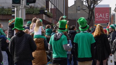 Geleneksel İrlanda şapkaları ve yeşil elbiseler giyen kalabalık Dublin, İrlanda 'da Aziz Patrick Günü geçit törenini izliyor.