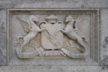 Glendalough, İrlanda 'daki Powerscourt malikanesinde Latin yazıtlı aile arması / arması.