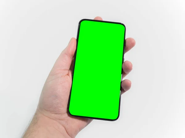 男性の手は緑の画面でスマートフォン 携帯電話を保持 — ストック写真