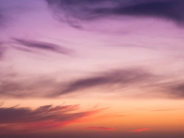 Beautiful smooth gradient sky, purple and red at sunset with soft, wispy clouds
