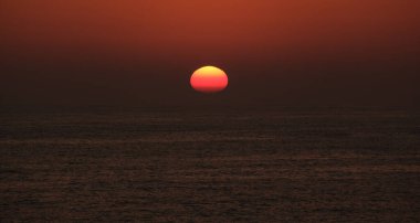 Güneş okyanusta gün batımında ufkun altında kayboluyor.