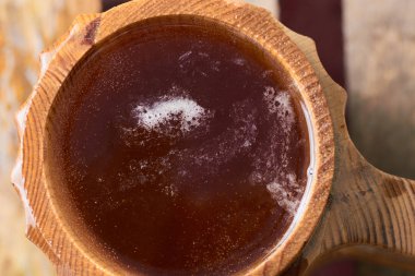 Olgun sulu yaz bir arka plan üzerinde ahşap bir kupa bira