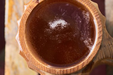 Olgun sulu yaz bir arka plan üzerinde ahşap bir kupa bira