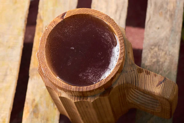 Olgun sulu yaz bir arka plan üzerinde ahşap bir kupa bira