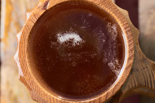 Olgun sulu yaz bir arka plan üzerinde ahşap bir kupa bira