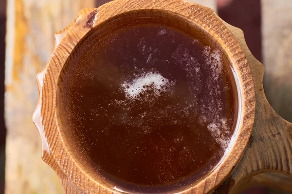 Olgun sulu yaz bir arka plan üzerinde ahşap bir kupa bira