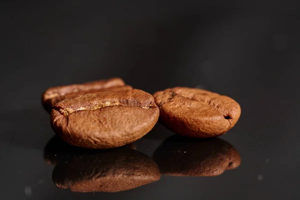 Grãos de café em fundo preto consistente com — Fotografia de Stock