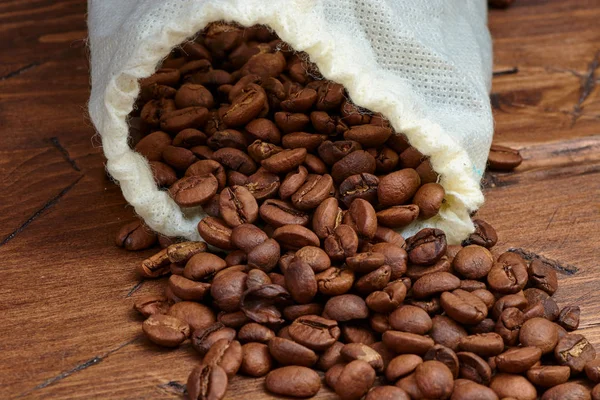 Coffee beans on a wooden background scattered — Stock Photo, Image