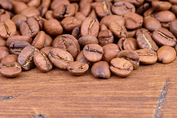 Coffee beans on a wooden background scattered Royalty Free Stock Images