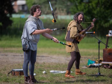 Reggio Emilia, İtalya - Mayıs 2017: Ateş hokkabaz el fenerleri ve Mandolin açık Fuarı'nda müzisyen ile.