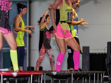 Mini ribauntçu egzersiz: Spor salonunda Fitness egzersiz yaparak kulaklık kızlarla.